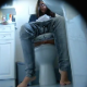 A hidden camera records a brunette girl wearing glasses as she wipes a stain from her panties and appears constipated while sitting on a toilet. Audio does not capture any noticeable poop sounds, but she wipes repeatedly. About 5.5 minutes.
